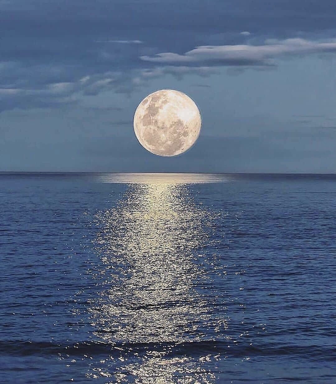 La luna sospesa all’orizzonte illumina il mare