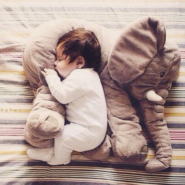 Neonato dorme con il suo piccolo pupazzetto elefante che lo protegge