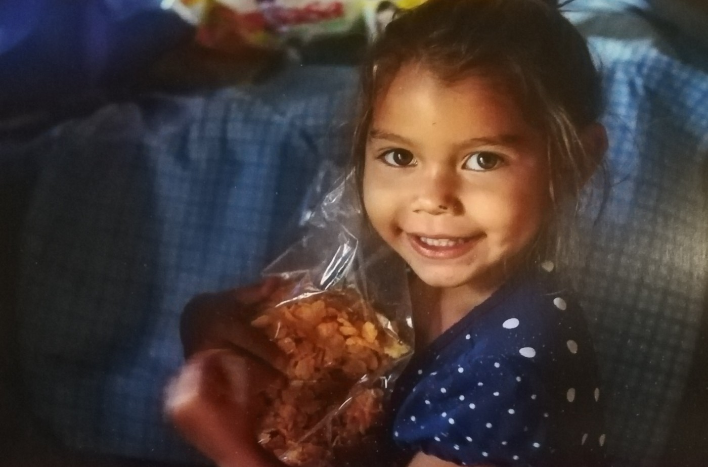 NICARAGUA Aleska, 2 anni, sorride mentre stringe il cibo che gli operatori hanno consegnato alla sua mamma