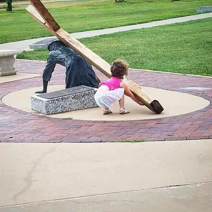 una bimba cerca di aiutare Gesù con la croce