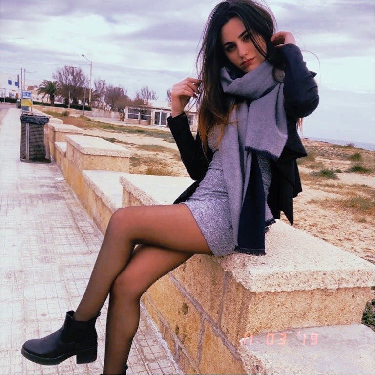 Lei sul lungo mare con indosso una sciarpa viola